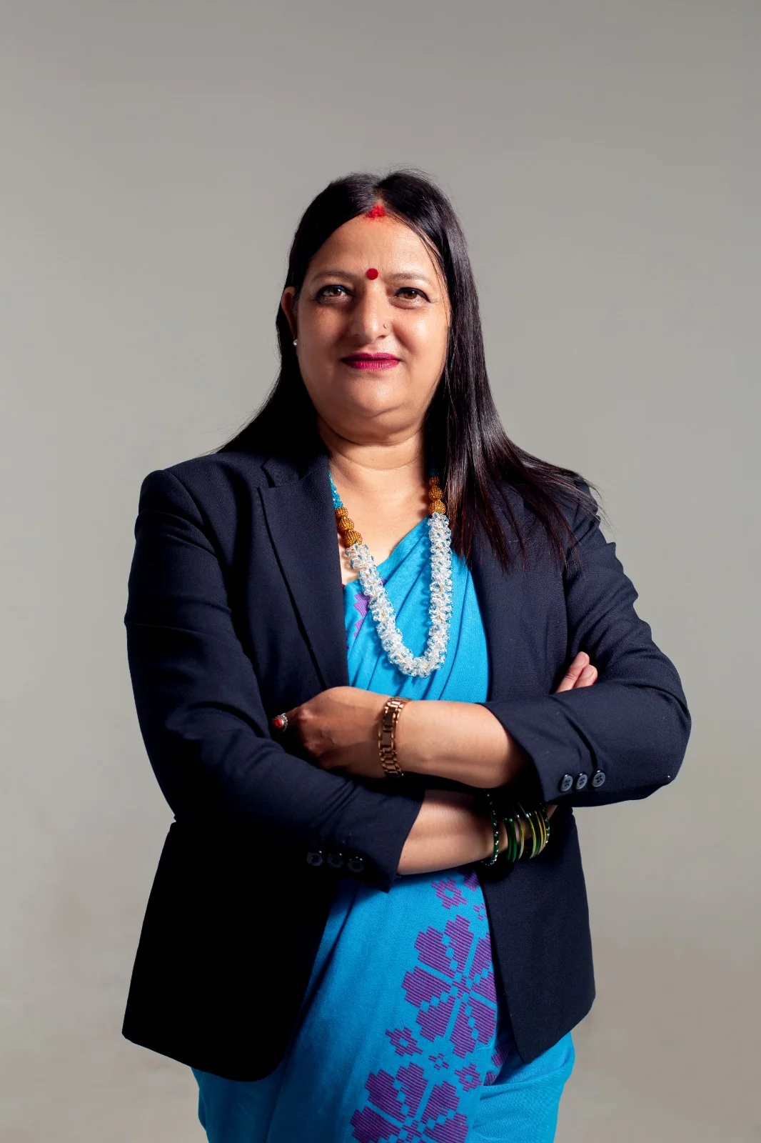 Saphala Dhungana in rsp party colors with arms crossed looking towards the front